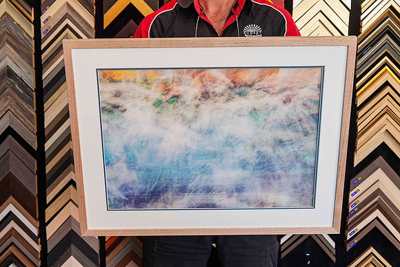 A single framed artwork from a Collection of artworks professionally framed with matching natural timber frames and individually colour-matched accent mounts for an exhibition at Sunset Framing & Gall