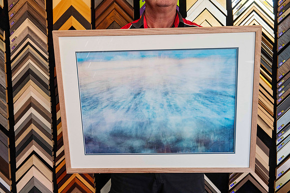 A single framed artwork from a Collection of artworks professionally framed with matching natural timber frames and individually colour-matched accent mounts for an exhibition at Sunset Framing & Gall