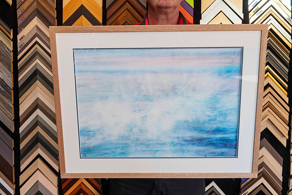 A single framed artwork from a Collection of artworks professionally framed with matching natural timber frames and individually colour-matched accent mounts for an exhibition at Sunset Framing & Gall