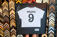 Signed Kylian Mbappé soccer jersey custom framed with black timber frame and conservation mounting by Sunset Framing & Gallery Port Macquarie.
