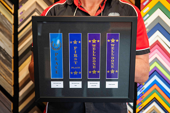 Kids athletics and sports award ribbons including first place and well done ribbons, professionally mounted and custom framed in Port Macquarie.