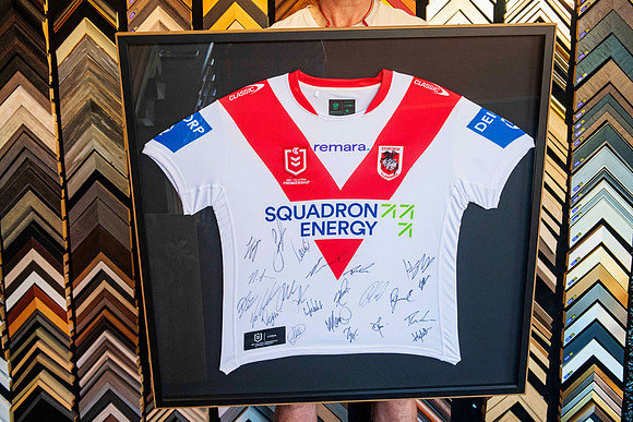 Team-signed St George Illawarra Dragons red and white NRL jersey professionally mounted and custom framed as sporting memorabilia in Port Macquarie.