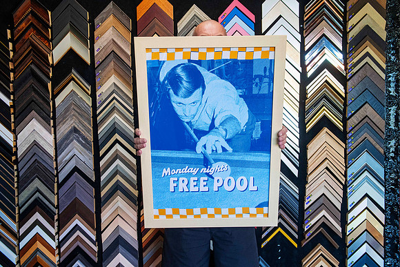 Blue retro-style Monday Nights Free Pool poster custom framed in light timber for Settlers Inn as part of a coordinated hotel décor collection in Port Macquarie.