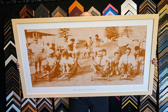 Historic local photograph of billy cart racing transformed into a large sepia poster and custom framed in light timber for Settlers Inn in Port Macquarie.