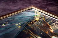 Picture frame with shattered glass after an ageing hanging cord broke and caused the frame to fall from the wall, requiring professional frame repair in Port Macquarie.