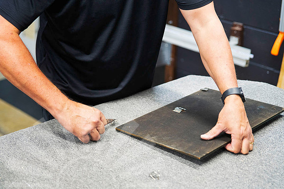 Old backing being removed from a vintage framed print as part of a complete professional reframe using updated framing materials in Port Macquarie.