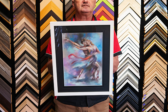 Colourful expressive artwork of a dancing couple custom framed with a wide black mat and contemporary white picture frame by Sunset Framing & Gallery in Port Macquarie.