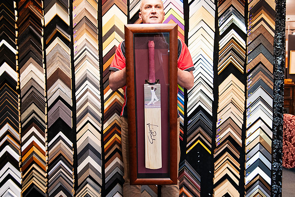 Signed Sir Viv Richards cricket bat with photograph custom framed vertically in a deep timber shadow box with burgundy background by Sunset Framing & Gallery Port Macquarie.