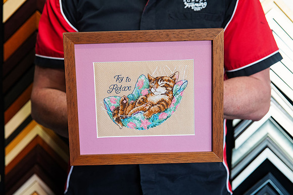 Handmade cat cross stitch reading “Try to Relax” custom framed with a dusty pink mat and warm timber picture frame by Sunset Framing & Gallery in Port Macquarie.