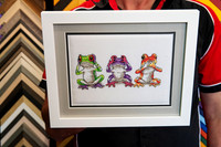 Colourful three frogs cross stitch framed with layered grey and black matting and a white custom frame in Port Macquarie.