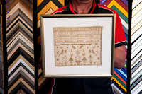 Vintage stitched sampler found inside an old book, custom framed with its original irregular textile edges visible in Port Macquarie.