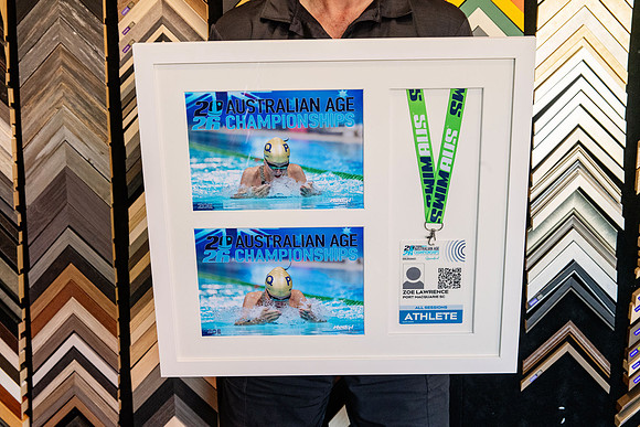 Swimming championship photographs, athlete credential and medal ribbon custom framed together.