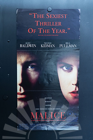 Malice Australian Daybill with shadowed close-ups of Alec Baldwin and Nicole Kidman, blue eyes, a red review quote above and the red film title below.
