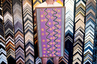 Purple Aboriginal artwork with detailed dot painting framed in a narrow timber frame.