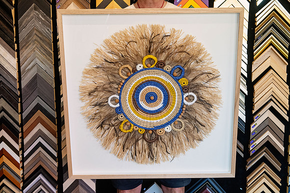 Woven fibre and feather artwork professionally custom framed in natural timber by a Port Macquarie picture framer.