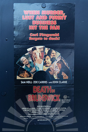 Death in Brunswick Australian Daybill with red and yellow lettering on black above a fan-shaped montage of film scenes featuring Sam Neill, Zoe Carides and John Clarke.
