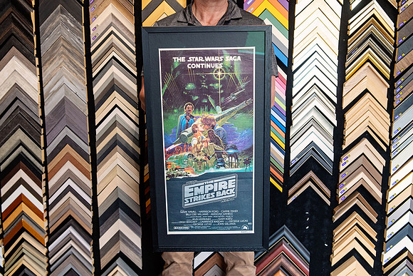 The Empire Strikes Back Star Wars movie poster custom framed with dark mat and black frame.