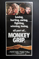 Monkey Grip Australian Daybill with four colour character portraits across the top, bold white lettering on black, and two clasped hands beneath the title.