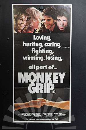 Monkey Grip Australian Daybill with four colour character portraits across the top, bold white lettering on black, and two clasped hands beneath the title.