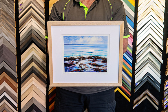 Coastal seascape artwork custom framed with white mat and natural timber frame.