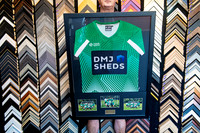 Green sports jersey custom framed with team photographs and plaque in Port Macquarie.