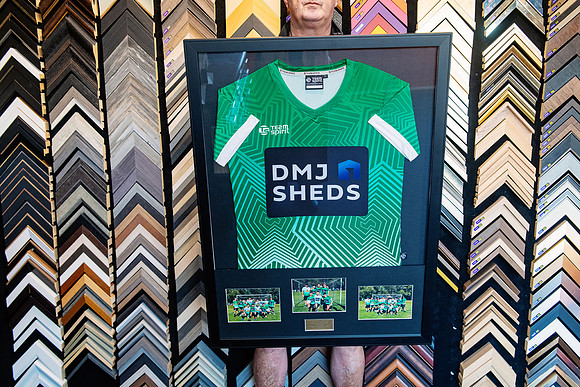 Green sports jersey custom framed with team photographs and plaque in Port Macquarie.