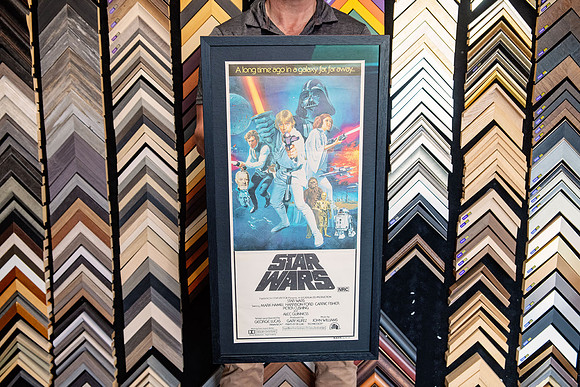 Classic Star Wars movie poster custom framed with dark mat and black frame.