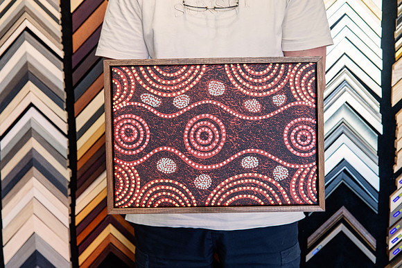 Orange black and white Aboriginal dot painting custom framed with a narrow timber frame.