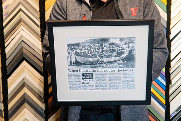 Historical newspaper clipping custom framed with neutral mat and black frame.
