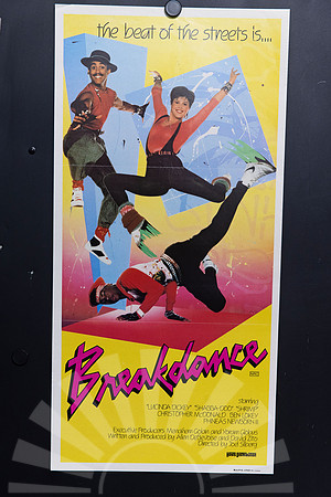 Breakdance Australian Daybill with three dancers posing against a yellow background, blue geometric panels and paint splashes, above a bold pink and black title.