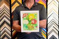 Small colourful floral painting professionally custom framed in a simple white picture frame.